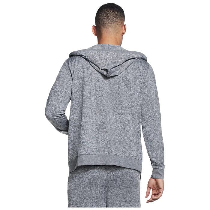 A person is wearing a gray hoodie with a hood pulled down while facing away from the viewer in a casual indoor setting. The outfit appears comfortable and sporty.