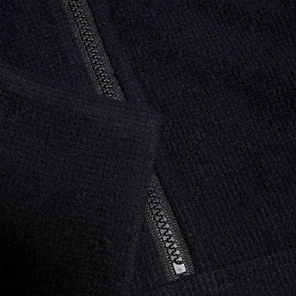 Black fabric with a textured surface features a visible zipper partially open at the edge suggesting an outerwear garment in a neutral background that highlights the material's softness and detail.