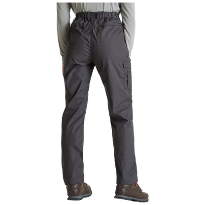 A person stands facing away, wearing dark gray cargo pants with an elastic waistband and pockets. They are paired with brown footwear, suggesting an outdoor or casual context.