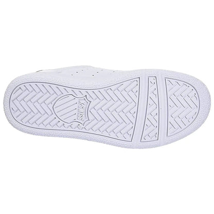 A white sneaker's sole is displayed with a textured pattern featuring a circular logo at the center and a herringbone design providing traction and grip for various surfaces.