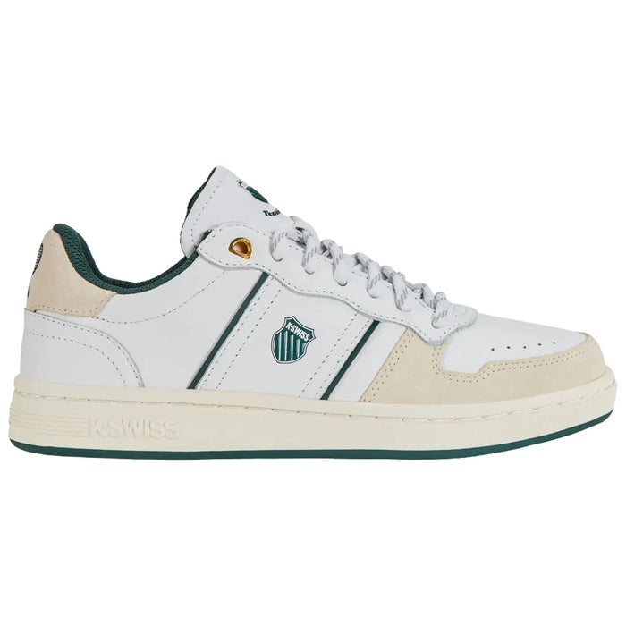 A white sneaker with green accents features two horizontal stripes and a logo on the side while resting on a plain surface in a neutral environment.