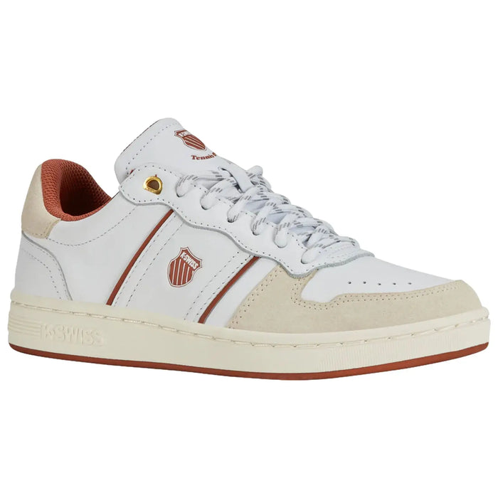 A white sneaker with a suede toe cap has gray laces and red accents on the lining and stripes. It features a logo and is set against a simple background.