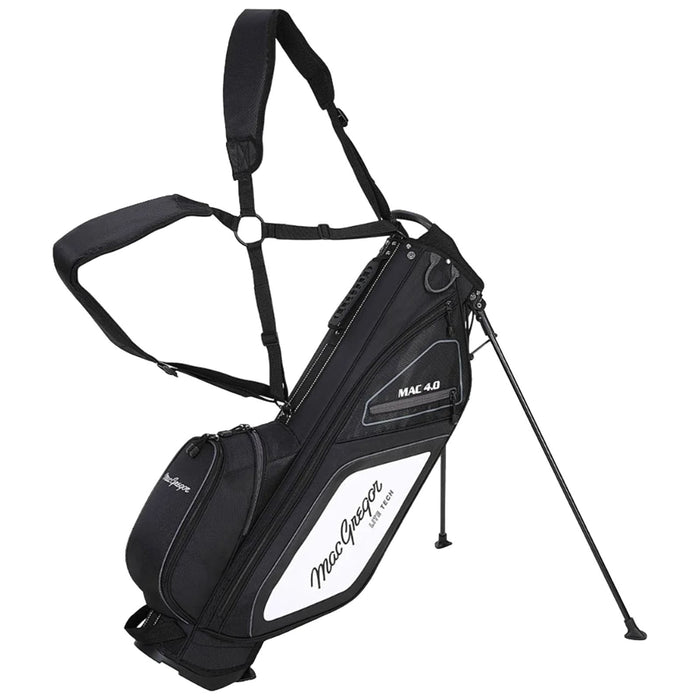 A black and white golf bag equipped with adjustable straps stands upright on its tripod legs with various zippered compartments for storage set against a neutral background.