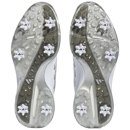 Two athletic shoes viewed from the bottom show a patterned gray outsole with six white cleats each designed for traction on grass or turf fields.