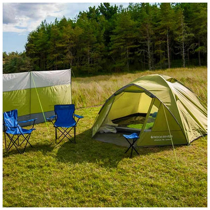 A green tent stands in a grassy area surrounded by trees while two blue folding chairs sit nearby offering a cozy camping setup in a natural outdoor environment.