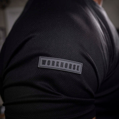 Model wearing Workhorse's Black Sport Performance T-Shirt with 'Workhorse' patch on the right sleeve.